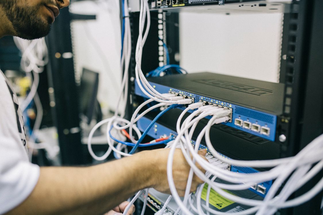 IT engineer fixing ethernet cables on a server rack, demonstrating hands-on server maintenance