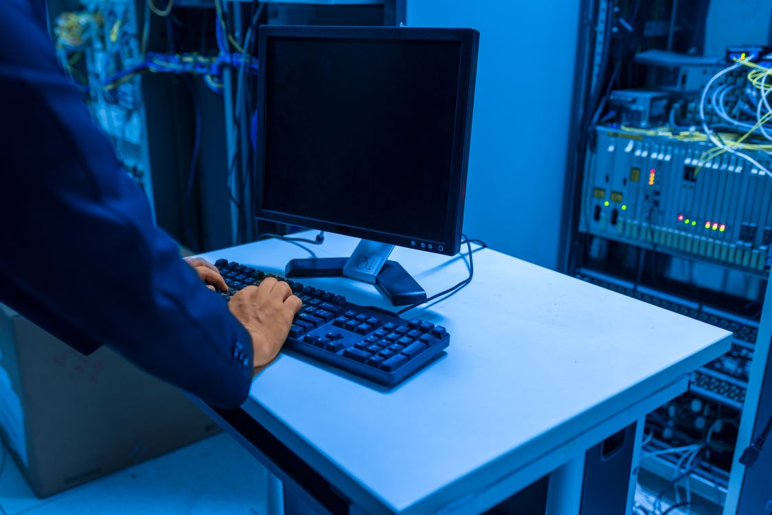 IT technician working at a computer terminal in a server room